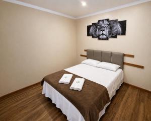 a bedroom with a bed with two towels on it at Lá Casa do Manguinha in Guarulhos