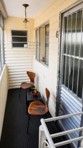 two chairs and a table on a porch at Lá Casa do Manguinha in Guarulhos