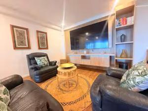 a living room with two couches and a large television at 2BR Oceanview Villas - Slice of Paradise, Central Suva in Suva