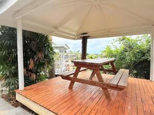 a wooden deck with a picnic table and an umbrella at 2BR Oceanview Villas - Slice of Paradise, Central Suva in Suva