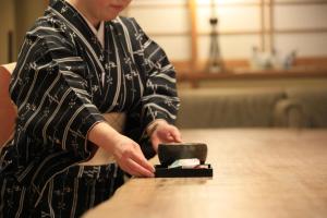 a man is putting something in a box on a table at Wakamatsu Hot Spring Resort in Hakodate