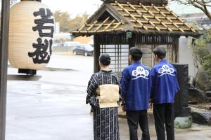 three people in kimonos standing in front of a shrine at Wakamatsu Hot Spring Resort in Hakodate