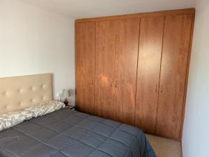 a bedroom with a large wooden cabinet next to a bed at Apartment near Fira Barcelona, Camp Nou, and the center of Barcelona in Hospitalet de Llobregat