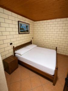a bed in a brick walled room with a bed sidx sidx sidx at Villa Adi in Ducaj