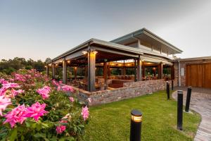 a house with a patio and flowers in the yard at Harrigan's Hunter Valley in Pokolbin