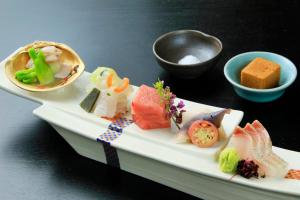 a plate of food with sushi on a table at Wakamatsu Hot Spring Resort in Hakodate