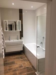 a bathroom with a tub and a sink and a shower at Appartement Feinsinn in Westendorf