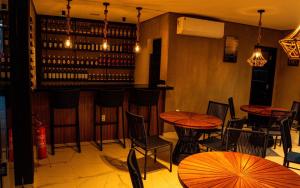 a bar with tables and chairs and wine bottles at Pousada Caribdis in Paraipaba