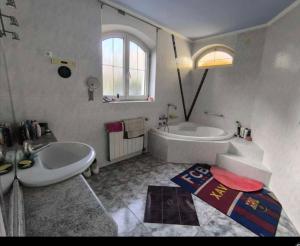 a white bathroom with a tub and a sink at Panorama Hills Villa in Budapest