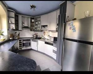 a kitchen with white cabinets and a stainless steel refrigerator at Panorama Hills Villa in Budapest