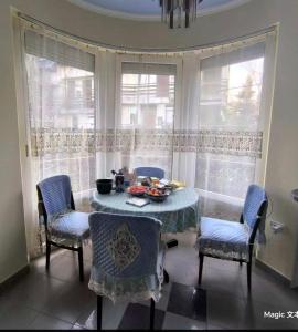 a dining room with a table and chairs and windows at Panorama Hills Villa in Budapest