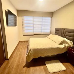 a bedroom with a bed and a window at Depar 1 Dormitorio F in Cochabamba