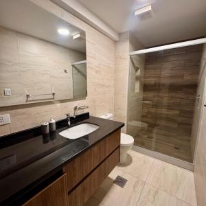 a bathroom with a sink and a toilet and a mirror at Depar 1 Dormitorio F in Cochabamba