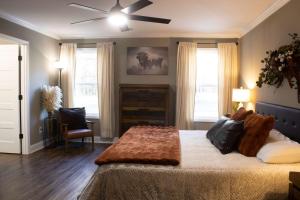 a bedroom with a large bed with a ceiling fan at Peach State Hideaway The Columbus Escape in Columbus