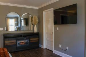 a living room with a fireplace and a tv at Peach State Hideaway The Columbus Escape in Columbus