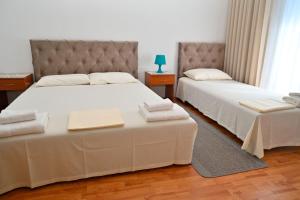 two beds sitting next to each other in a room at Adriatic Garden Rooms in Bregvija +5 photos