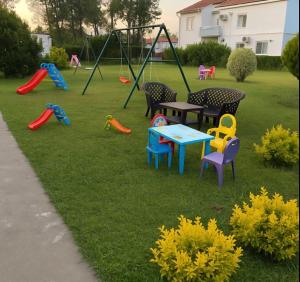 a playground with colorful chairs and tables in a yard at Adriatic Garden Rooms in Bregvija