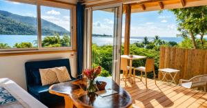 a living room with a view of the water at Aimeho Bungalow in Paopao +9 photos
