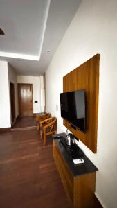 a room with a flat screen tv on a wall at Hotel Chhaya in Rishīkesh