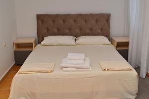 a bedroom with a bed with two towels on it at Adriatic Garden Rooms in Bregvija
