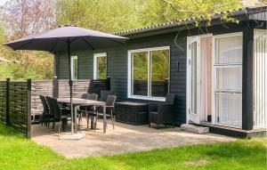 a patio with a table and chairs and an umbrella at Holiday Home Gedser 07 in Gedser