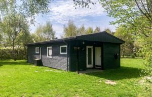 a small green shed in a grassy field at Holiday Home Gedser 07 in Gedser