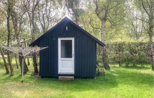 a black shed with a white door in the grass at Holiday Home Gedser 07 in Gedser +10 photos
