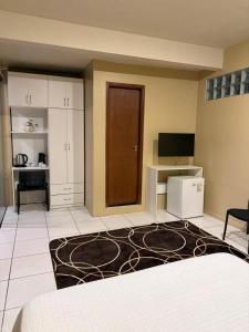 a hotel room with a bed and a tv and a room at Refugio Centrico in Ciudad del Este