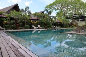a swimming pool with chairs and umbrellas in a resort at Kaimana Resort Siargao in General Luna