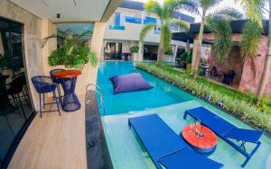 an empty swimming pool with blue tables and chairs at Pousada Caribdis in Paraipaba