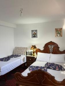 a bedroom with two beds and a table with a lamp at Magic View in Bine el Ouidane