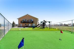 a fenced in golf course with a playground with a house at Sunset Vista in Garden City