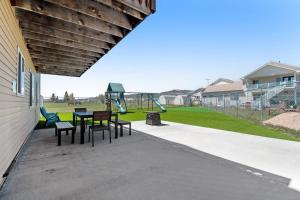 a patio with a table and chairs and a playground at Sunset Vista in Garden City