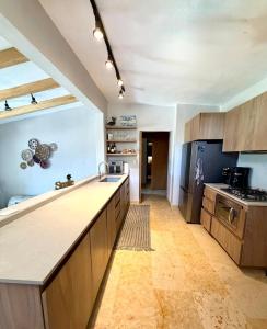 a kitchen with wooden cabinets and a counter top at Villas Mimosa at La Ropa Beach in Zihuatanejo
