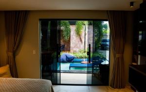 a bedroom with a glass door leading to a patio at Pousada Caribdis in Paraipaba