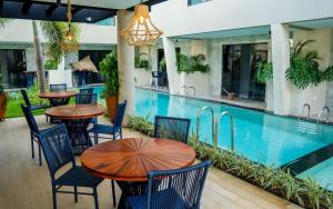 a restaurant with tables and chairs next to a swimming pool at Pousada Caribdis in Paraipaba