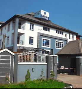 a white building with a sign on top of it at Benyster Hotel in Gwarinpa