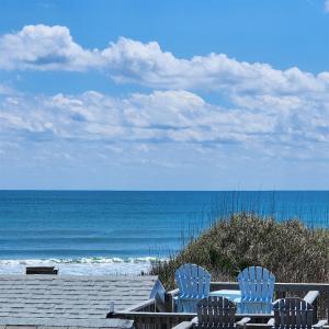 two chairs and a table on a beach with the ocean at NC 12 56821-9 Condo in Hatteras