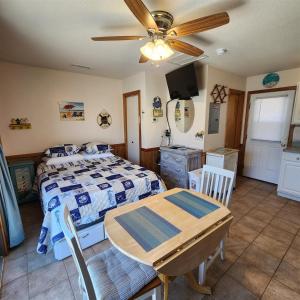 a bedroom with a bed and a table and a ceiling fan at NC 12 56821-9 Condo in Hatteras +2 photos