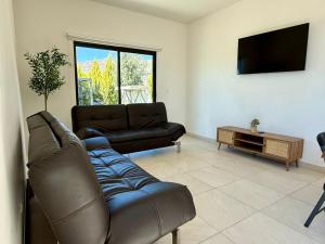 a living room with a couch and a flat screen tv at Departamentos Aremay in Cuatrociénegas de Carranza