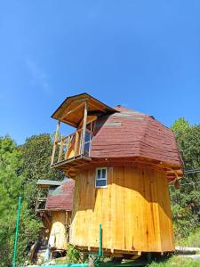 a tree house with a roof on top of it at Hongos mágicos in San Mateo Río Hondo