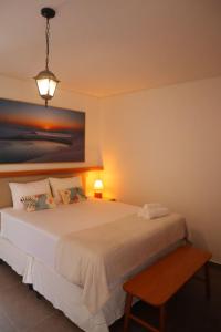 a bedroom with a bed and a painting on the wall at Pousada Vila Pequi in Barreirinhas