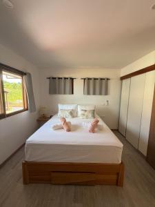 a bedroom with a large bed with white sheets and a window at Le Rainoa - Beach House in Taputapuapea
