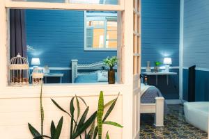 a blue bathroom with a bed and a tub at The Nomad Hostel - SJO Airport San Jose 5 min - Private, WiFi & Coffee in Alajuela
