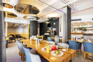 a dining room with a long wooden table and chairs at Metro Hotel Perth City in Perth
