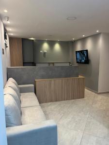 a waiting room with a couch and a flat screen tv at Hotel Provenza Suites in Ocaña