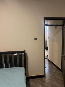 a bedroom with a bed and a door to a hallway at AJ Space in Kampala