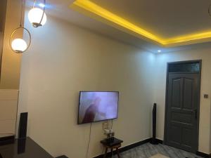 a flat screen tv on a wall next to a door at AJ Space in Kampala