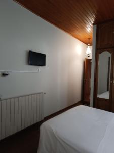 a bedroom with a bed and a tv on the wall at São Neutel in Chaves