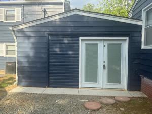 a garage with a door on the side of a house at Cozy and Chic Burlington Retreat in Burlington